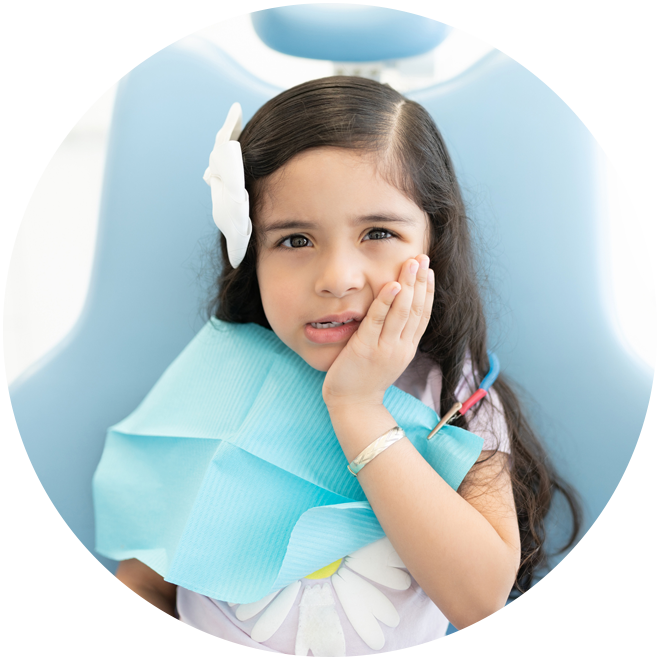 Young girl with angel wings and halo, resting cheek on hand, smiling at camera.
