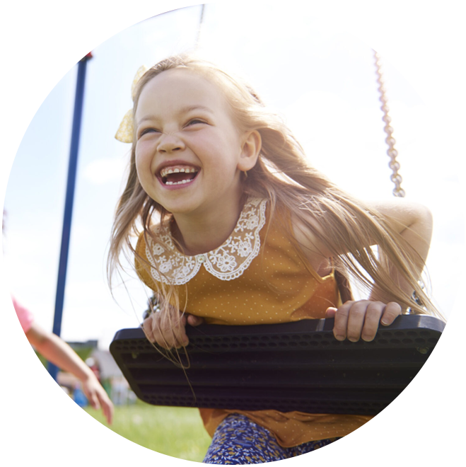 Happy young girl on amusement park ride, smiling with joy and excitement.