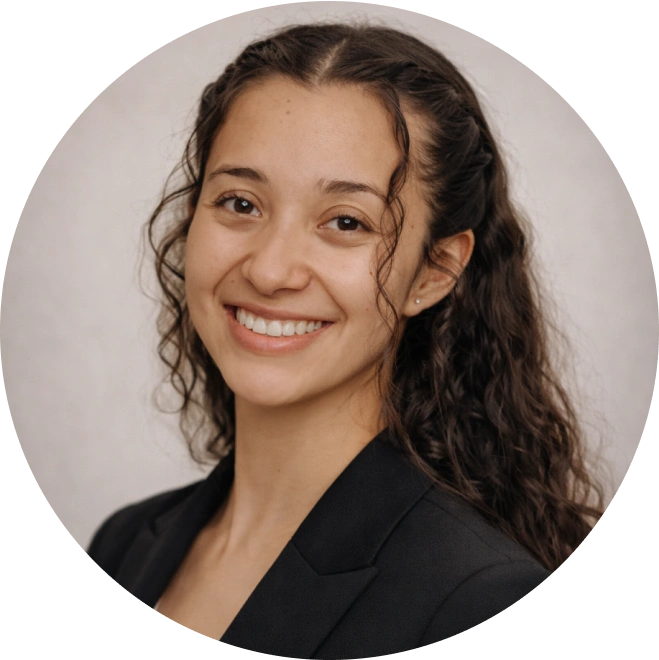 Professional headshot of smiling woman in black blazer against neutral background.