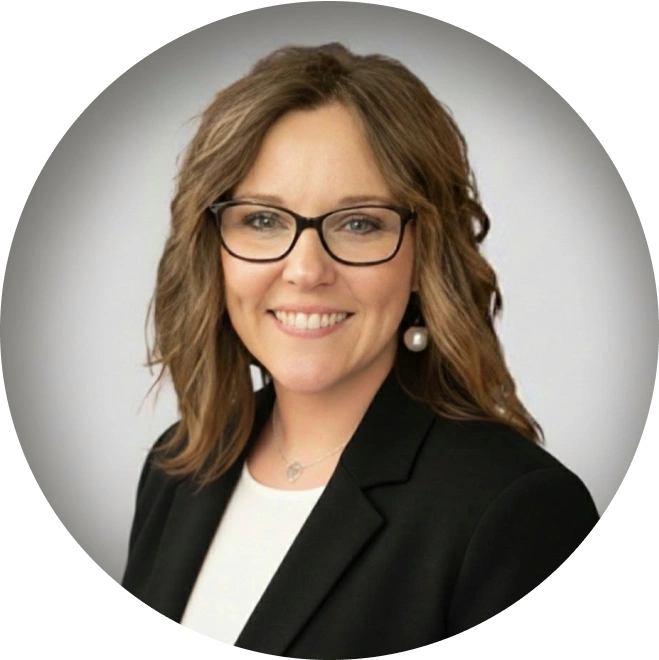 Professional headshot of woman wearing glasses and black blazer smiling at camera.