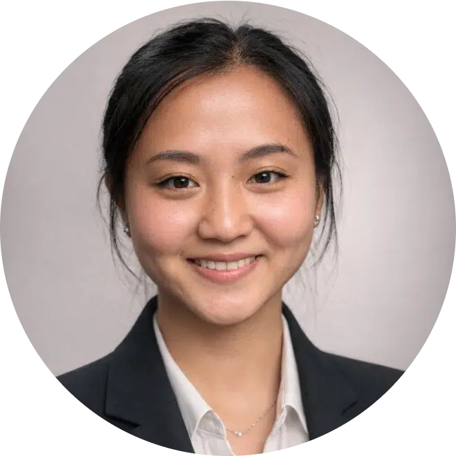 Professional headshot of smiling female dentist in business attire against neutral background.