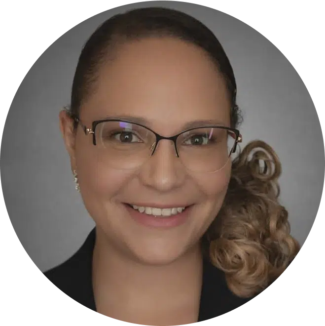 Young woman wearing glasses smiling at camera, professional headshot portrait.